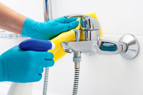 Domestic cleaner tidying a kitchen in a West London property